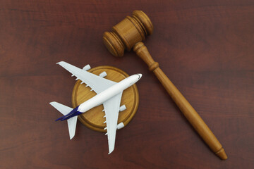 Flight cancellation, aviation law, sue airline company concept. Wooden judge gavel and airplane...