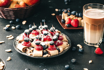 Breakfast pancake. A healthy breakfast with fruit. Pancake with fruit. Iced coffee and fruit. Dark background with pancakes and fruit. - obrazy, fototapety, plakaty