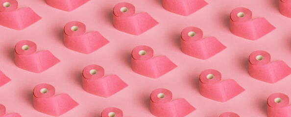 Rolls of pink toilet paper on pink background. panoramic pattern