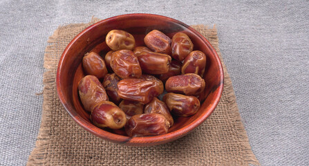 Dates in wooden bowl on background. dried dates fruit.