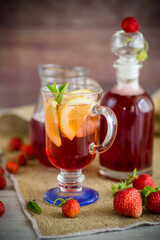 refreshing cool strawberry lemonade with lemon, ice and mint in a glass