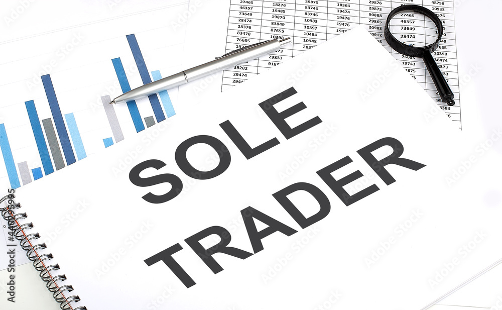 Poster in the notebook, the text sole trader , next to magnifier and a pen, the background is graphics.