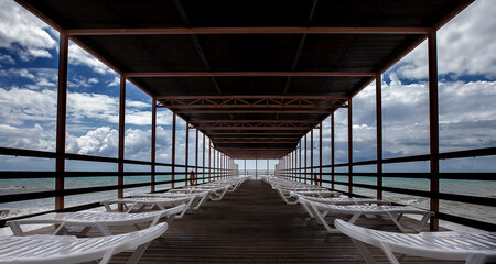 chaise lounges under a canopy, view on the sea