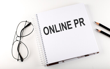 Notepad with text ONLINE PR . White background. Business concept