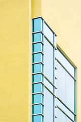Geometric pattern of glass wall on modern yellow building in vertical frame, low angle and perspective side view