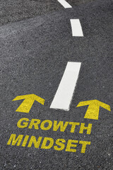 Growth mindset with yellow arrow marking on road surface with white marking line. Optimism empathy personality concept and motivation to success idea