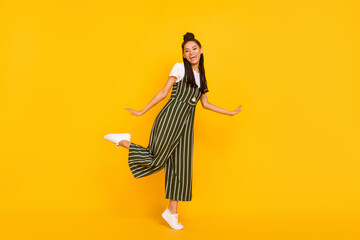 Full length photo of adorable pretty dark skin lady wear striped clothes dancing smiling isolated yellow color background