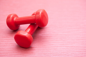 Red dumbbells set on pink background, sport and fitness concept