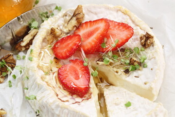 Camembert with strawberries and wine on a white background