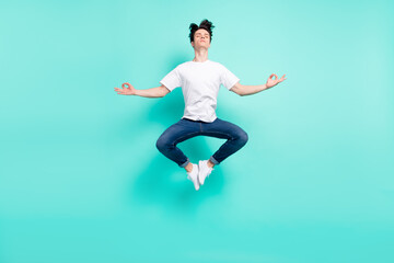 Fototapeta na wymiar Full body photo of rest brunet hairdo teen guy jump do yoga wear t-shirt jeans isolated on teal background