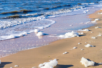 Image of sea foam on a sandy beach.