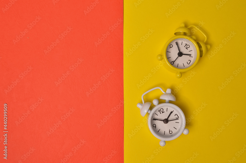 Wall mural Alarm clock isolated on yellow and red background