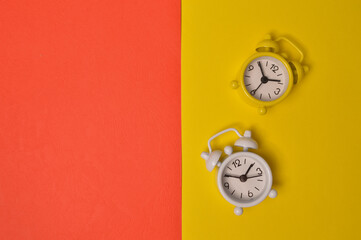 Alarm clock isolated on yellow and red background