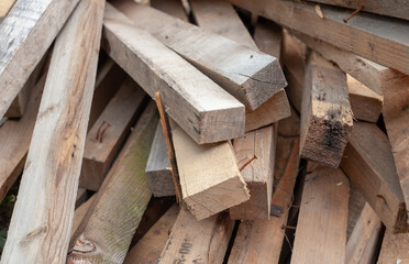 Stacked planks of disassembled pallets with more nails in them.
