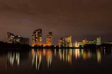 Fototapeta premium night city with reflection of houses in the river