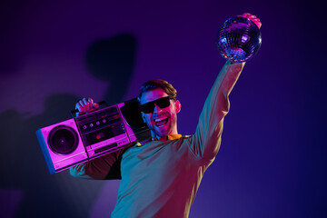 Photo portrait of man in sunglass keeping retro tape recorder disco ball listening music isolated...
