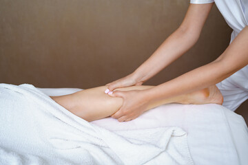 Obraz premium Professional massage therapist massages the soles, legs of adult woman lying on massage table, close-up. Lady gets relaxing massage. Concept of body care.