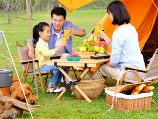 Happy family of three and dog camping out