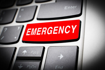 Red emergency button on the keyboard of computer, dark vignetting effect. The concept of an...