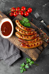  Grilled minced beef and pork sausages with barbecue sauce on wooden cutting board top view vertical photo
