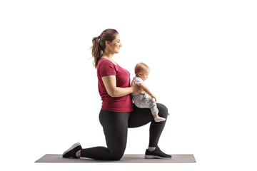 Young mother kneeling and exercisingwith her baby girl