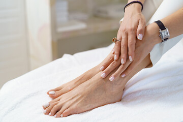 Obraz na płótnie Canvas Manicure pedicure close up on white perfect shape hands spa salon