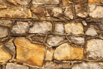 A wall of natural uneven,  stones. Texture for background.