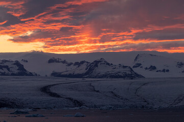 Snowy mountains against sunset sky