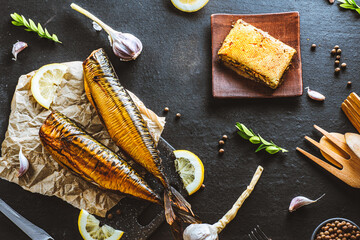 Mackerel. Smoked mackerel with additions. Fish with spices. Smoked food on a dark background.
