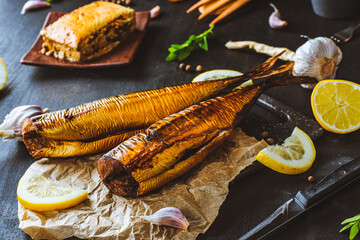 Mackerel. Smoked mackerel with additions. Fish with spices. Smoked food on a dark background.