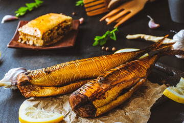 Mackerel. Smoked mackerel with additions. Fish with spices. Smoked food on a dark background.