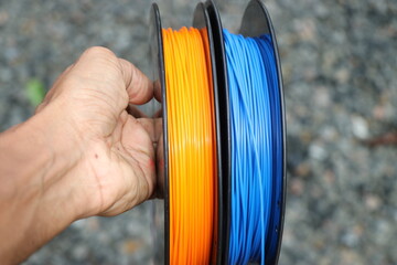 Filament for 3d printer held in hand. Material use to make this is polylactic acid or polylactide...