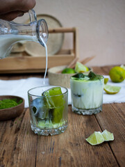 still life on a beige wooden background with matcha tea and milk