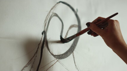 Unknown woman creating picture in workshop. Painter hand painting in studio.