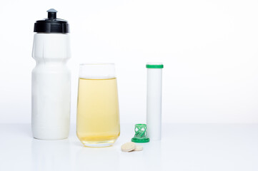 Sports water bottle. Flask and glass with vitamins. Preparing a sports drink. Sports flask isolate and isotonic.