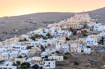 Fototapeta na wymiar Upper Side of Syros Island in Greece, During Sunset Time. Catholic Church at the Top of the Hill. Traditional White Houses Form a Pattern.
