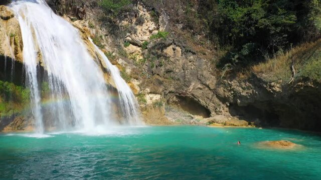 Girl diving into tropical waterfall pool, paradise idyllic travel destination