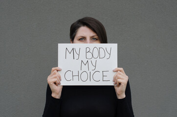Woman showing protest banner with the message my body my choice. Right to abortion. Stop discrimination. - obrazy, fototapety, plakaty