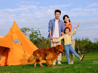 Happy family of three and pet dog in the park