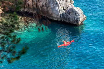 Fototapeta premium A man on a kayak swims on the sea
