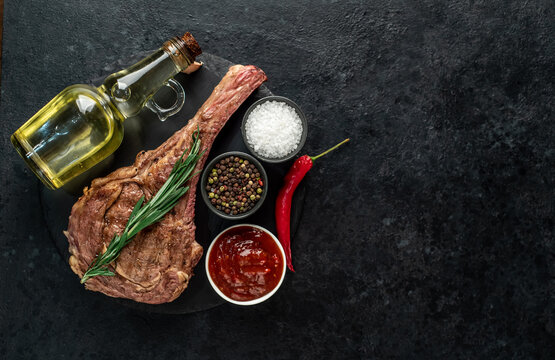 Grilled tomahawk steak on stone background with copy space for your text