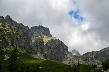 Fototapeta premium Sharp green grassy rocky mountain peaks of the High Tatra mountains during a cloudy day. hiking and adventure