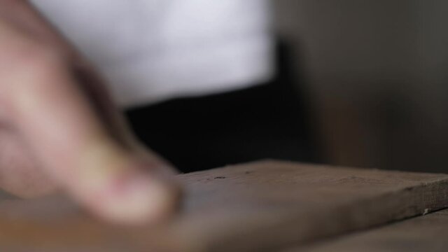 close-up. a worker pulls a nail out of a piece of wood using pliers. work with a tool in a workshop