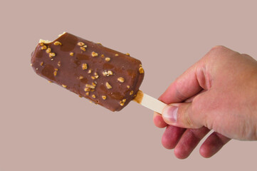 Chocolate vanilla Ice Cream Bar with nuts isolated in brown background copy space