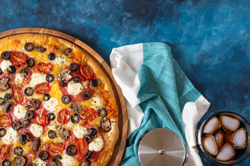 In the lower left corner of the photo, we see pizza on a wooden plate. There is a pizza knife on a...