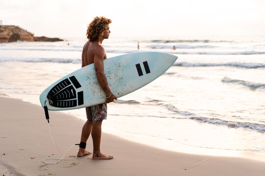 Young caucasian man get up early to doing surf at sunrise - Powered by Adobe