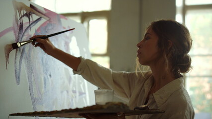 Creative woman creating artwork indoors. Talented painter drawing in art studio.