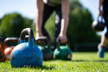 kettlebells in green grass - fitness concept outdoors 