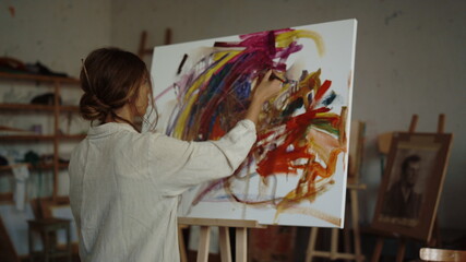 Inspired woman drawing in studio. Creative painter creating artwork indoor.