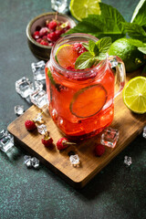 Summer drinks, bar soft beverage. Refreshing glasses drink raspberry with mint lime and ice on a dark stone table. Copy space.
